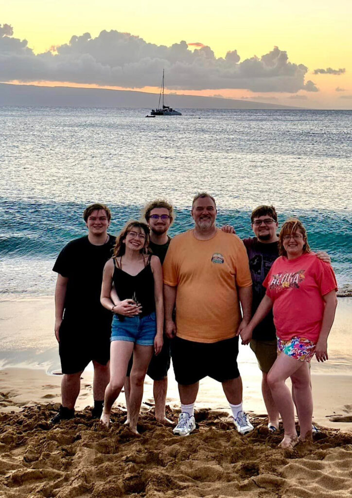 a group of people posing for a photo on a beach