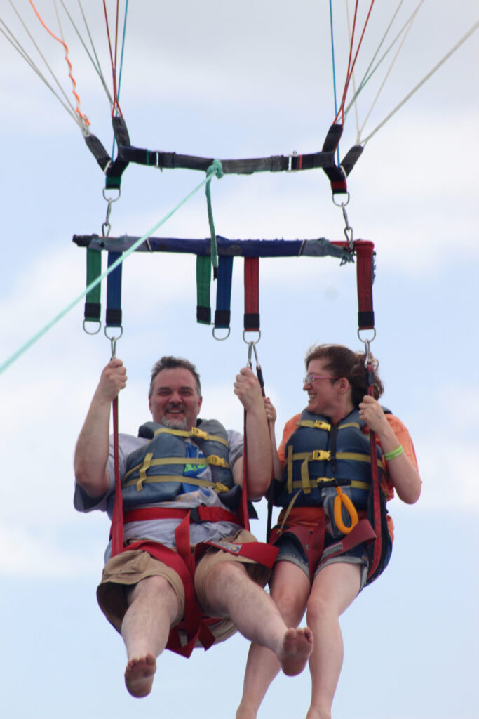 two people hanging in a swing with faces full of excitement