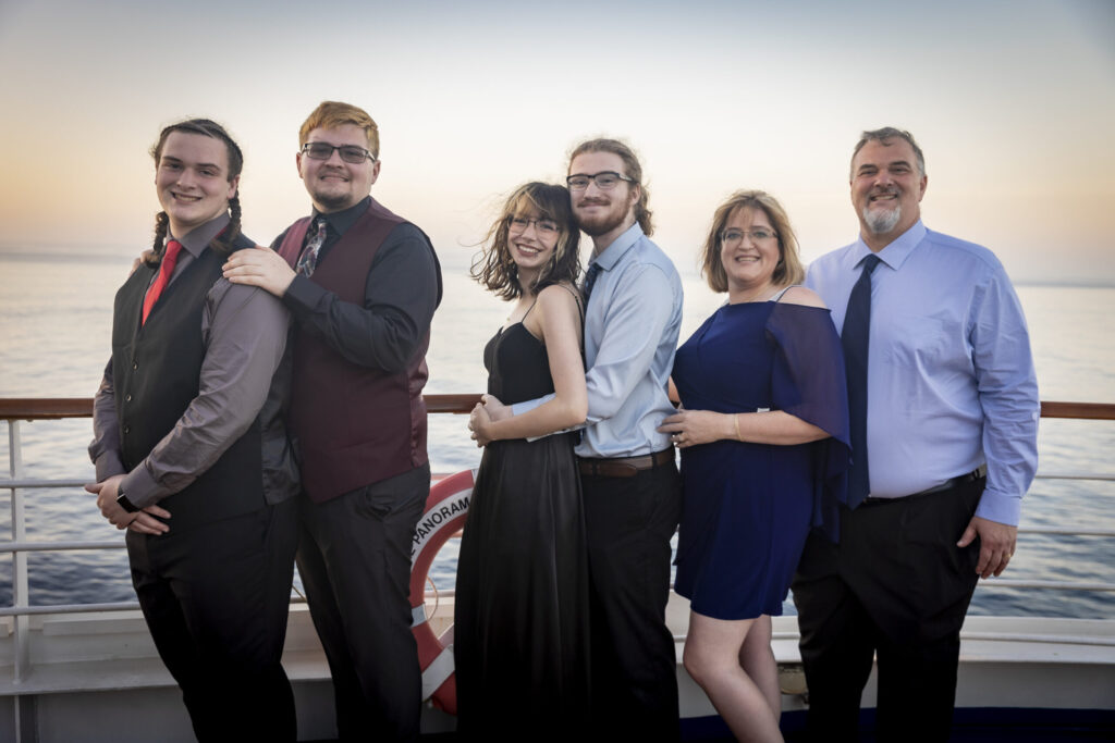 a group of people posing for a photo with ocean in the background